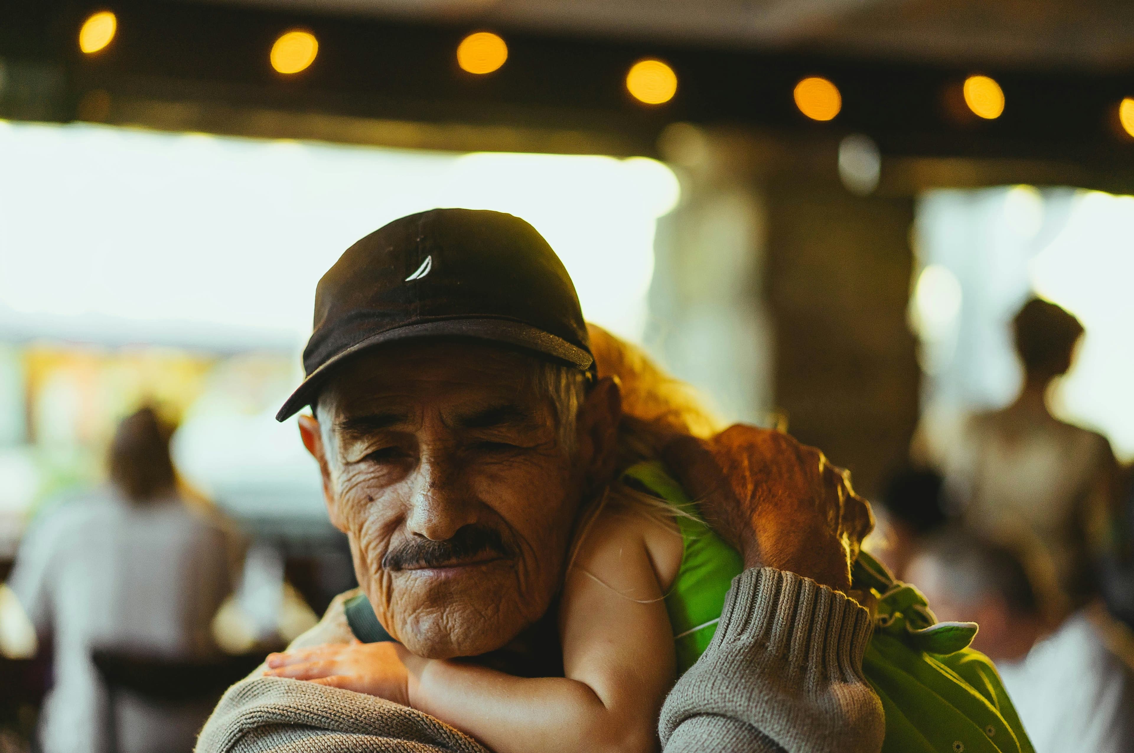 Grandfather embraces young child on his shoulder