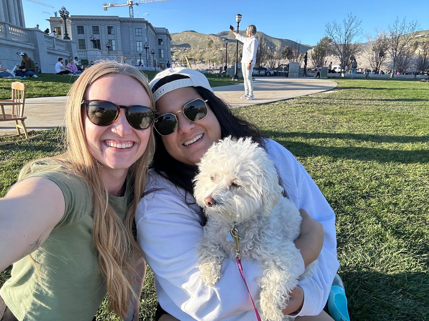 Two women and a dog in front of the Utah State Capitol